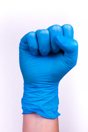 hand in blue glove in a fist scat.の写真素材