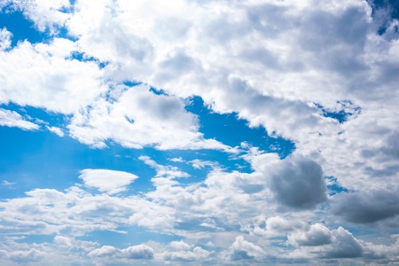 Blue evening sky white fluffy clouds background.の写真素材