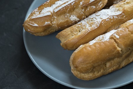 Eclairs with the filling on the plate is a traditional French dessertの写真素材