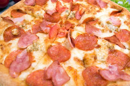 pizza pepperoni close-up on the table with tomatoesの写真素材