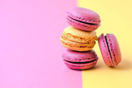 colorful french macarons on yellow with pink backgroundの写真素材