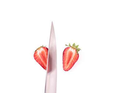 Strawberry closeup sliced with a knife on a white backgroundの写真素材