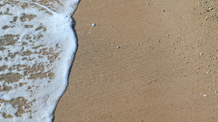 sea foam on the sand beach top view