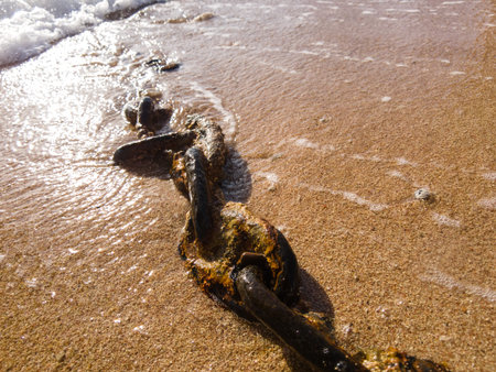 rusty chain on the beach close-up.