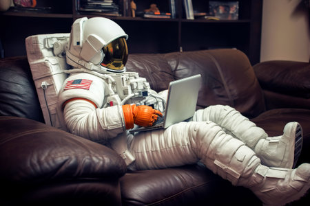Astronaut using tablet pc while sitting on sofa at home. Generative AI.の素材