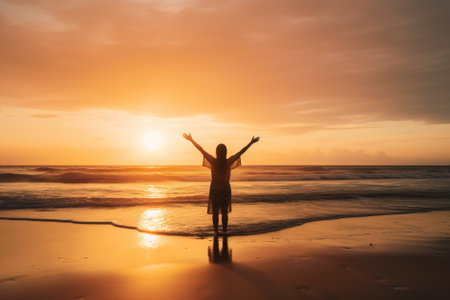 Silhouette of happy woman with raised hands on the beach at sunset. Generative AI.の素材