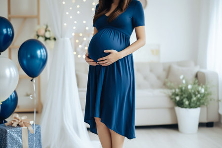 Pregnant woman in a blue dress on a background of a decorated roomの素材