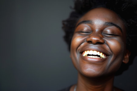 A woman with a big smile on her face. She is wearing a black shirt and necklace. Scene is happy and joyfulの素材