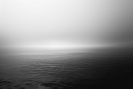 A calm body of water with a foggy sky in the backgroundの素材
