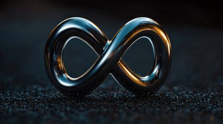 A silver and gold infinity symbol is on a black surface. The symbol is surrounded by a dark background, which gives it a sense of depth and mysteryの素材