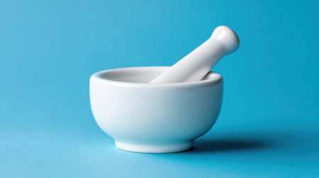 A white mortar and pestle set rests on a vibrant blue background, highlighting its smooth design. This tool is essential for grinding herbs and spices in culinary and medicinal practices.の素材