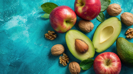 A blue background with a variety of fruits and nuts, including an open avocado and two apples. Concept of abundance and freshness, with the fruits and nuts representing a healthyの素材