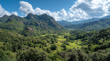 A breathtaking landscape shows rolling green valleys nestled between towering mountains and fluffy clouds.の素材