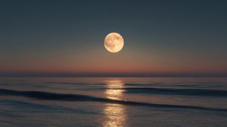 A large moon is reflected in the water of the ocean. The sky is dark and the moon is the only light sourceの素材
