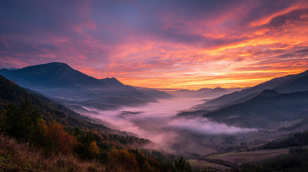Colors burst in the sky as mist blankets the peaceful valleys and hills at dawn.の素材