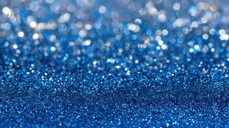 A close-up view of blue glitter scattered across a surface reflecting soft light. The shiny particles create a stunning bokeh effect enhancing the overall beauty.の素材