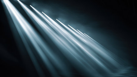 Bright beams of light shine through a dark environment creating a moody and dramatic atmosphere that sets the tone for an unforgettable evening event filled with excitement.の素材