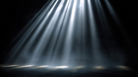 In a dark setting multiple beams of bright white light stream down from above illuminating the ground below.の素材
