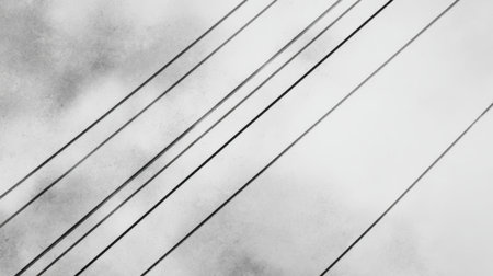 Cables are arranged diagonally against a cloudy backdrop creating a contrast in an urban environment.の素材