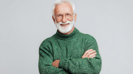 An older gentleman with a joyful smile and white beard stands with arms crossed radiating comfort and style.の素材