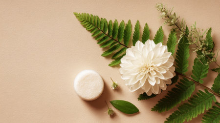A selection of natural beauty items features a white flower, green leaves, and a soap bar resting on a beige surface. It highlights a peaceful and calming aesthetic.の素材