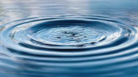 Small object creates ripples in calm water reflecting light and the surrounding peaceful environment.の素材