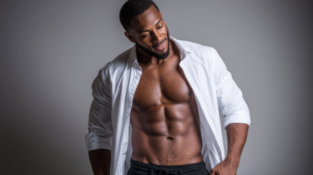 A man with a muscular body is wearing a white shirt and black shorts. He is posing for a picture and he is confident and proud of his physiqueの素材
