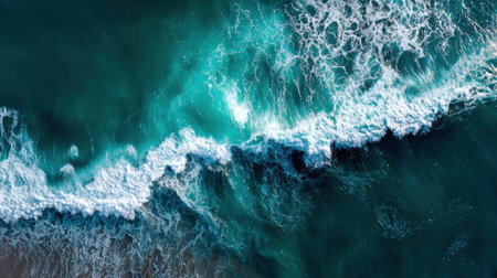 Bright sunlight reflects off the turquoise water as waves roll onto the sandy beach. The frothy white caps create a vibrant contrast with the deep blue ocean.の素材
