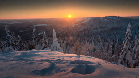 Majestic winter sunset over snowy mountain landscape with frosted trees.の素材