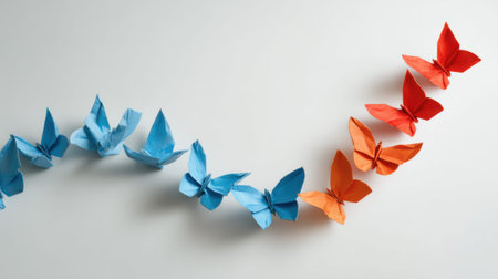 Origami butterflies in blue and orange on white background.の素材