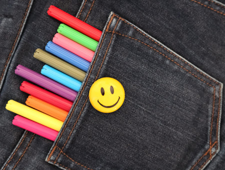 Felt pens in the pocket of gray jeans and smile. The concept of creative materials that are always...