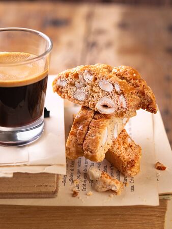 Traditional pastries, Italian homemade biscotti cookies or cantuccini, with almonds nuts and coffee. Wooden background with copy space. Close up. Still Life concept, bakery product. Selective focus.の写真素材