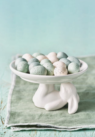 Decorative Polystyrene easter eggs on cake stand in the shape of a rabbit. Copy space, selective...