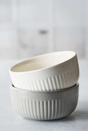 Two Rustic Ceramic Bowls white, gray Color Monochrome Baking background. Kitchen utensils for mixing ingredients . Cook at home. Selective focus.の写真素材