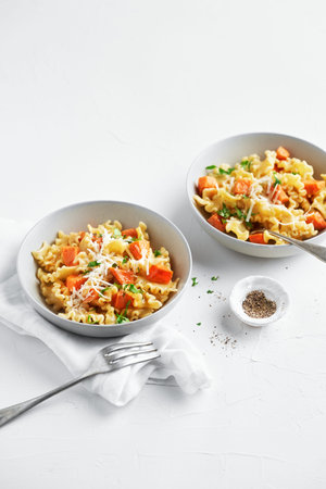 Italian pasta Mafalda Corta trafilata al bronzo with sauteed sweet potato, fennel, parmesan grated cheese on white background. Vegetarian meatless food. Copy space, not people.の写真素材