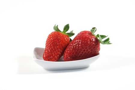 Two strawberries on white little dishの写真素材