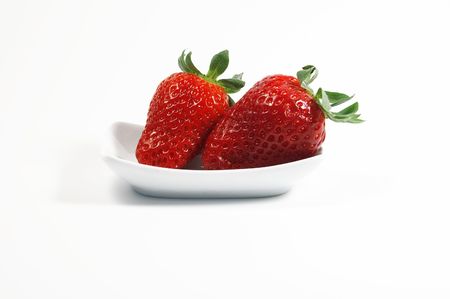 Two strawberries on white little dishの写真素材