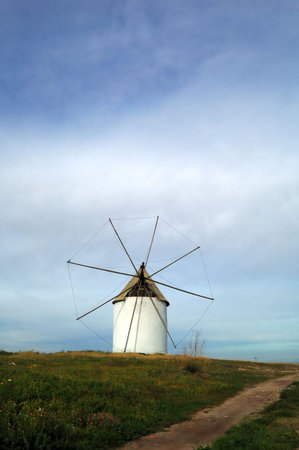 Typical spanish windmill in a meadow, rural landscape with country roadの写真素材