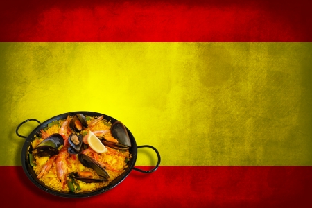 Traditional spanish dish: paella valenciana on spanish flagの写真素材