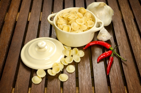Uncooked Orecchiette, italian pasta, in a bowl with ingredientsの写真素材