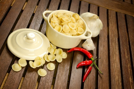 Uncooked Orecchiette, italian pasta, in a bowl with ingredientsの写真素材