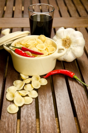 Uncooked Orecchiette, italian pasta, in a bowl with ingredientsの写真素材