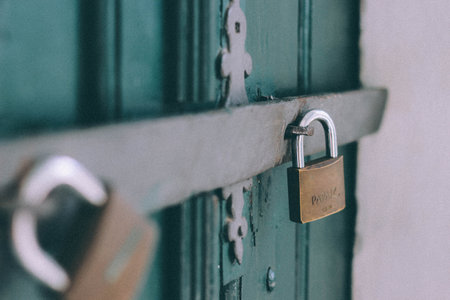 Padlock on a green wooden door. Concept of security, protection and privacy.の写真素材