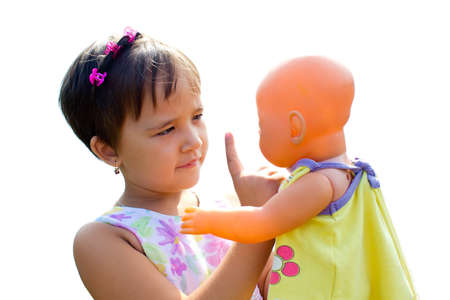 a little girl with a doll in his hand, isolate on white backgroundの写真素材