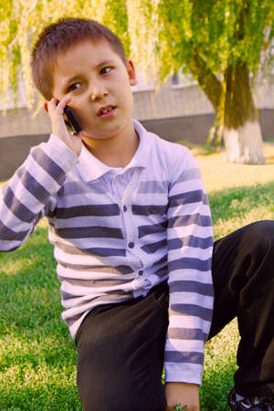 student with a mobile phone next to a schoolの写真素材