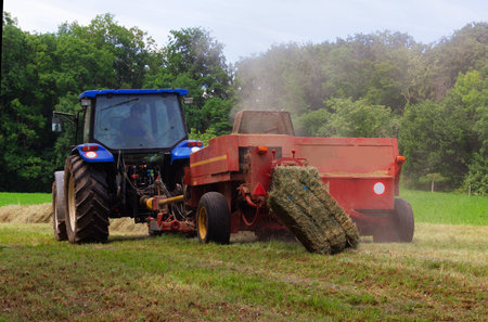 tractor removes the grass on the farmの写真素材