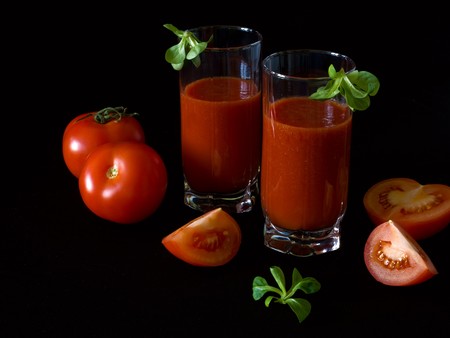 Fresh tomatoes and a two glasses full of tomato juice.の写真素材