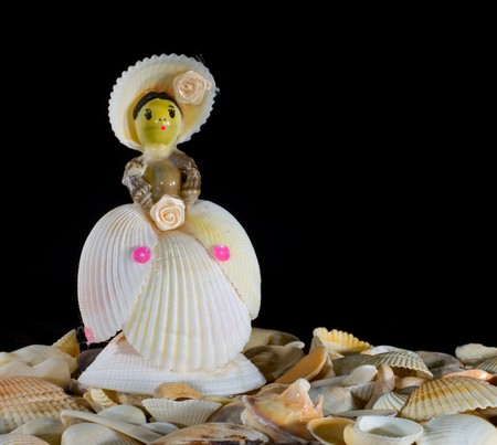 figurine made of colored shells, beads and ribbons on a black backgroundの写真素材