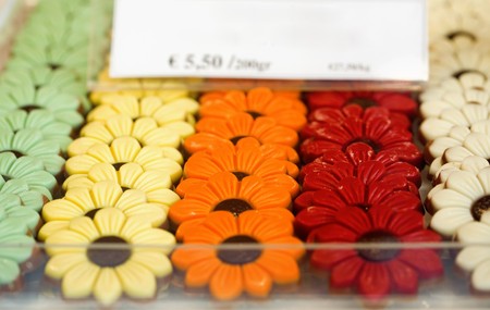 Colorful Belgian chocolate in the form of flowers on a shop windowの写真素材