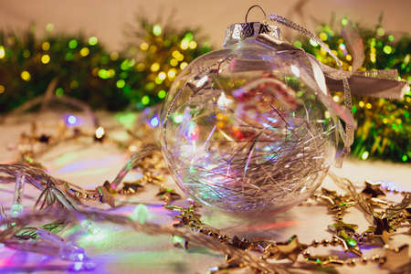 New Year, Christmas background. Glass ball on a background of garlands and ornaments, selective focusの写真素材
